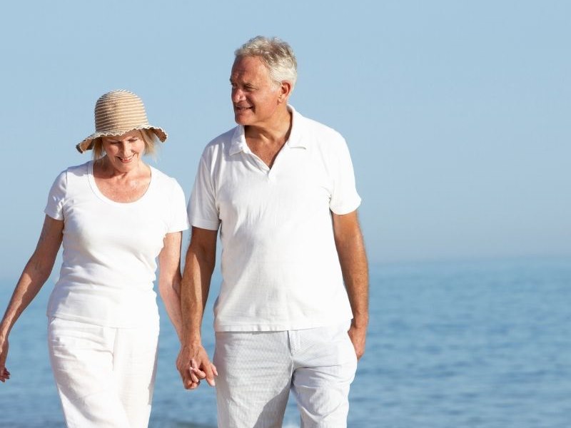 seniors walking on the beach holding hands